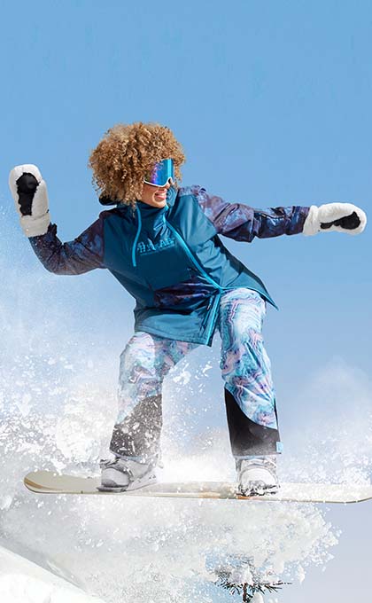 The model poses in a ski outfit on the snowboard