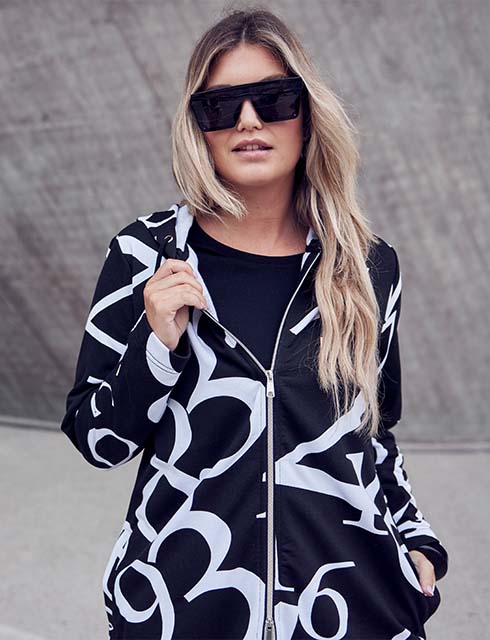 Close up of model in black and white patterned sweat jacket 

