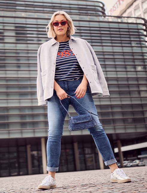 The model is wearing a striped shirt and a gray jacket