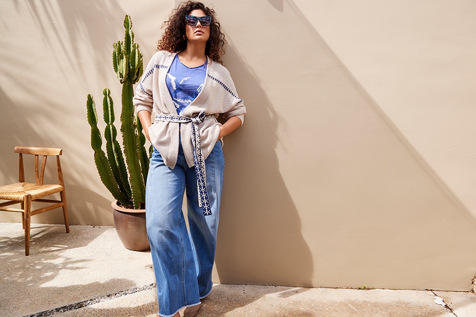 The model wears a cardigan with wide jeans