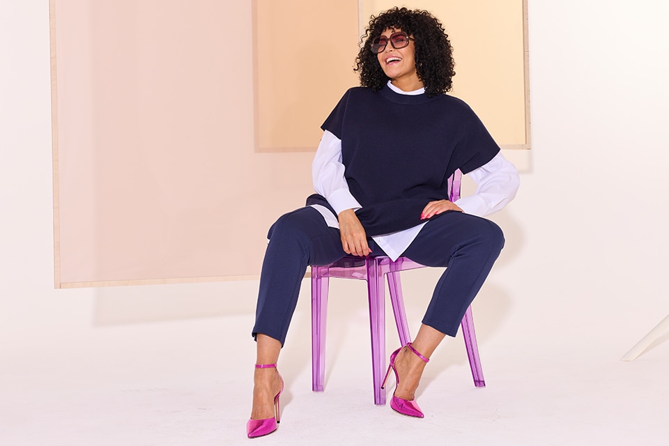 The model is wearing a blue knitted top
