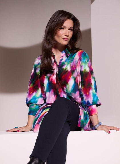 The model wears a colorful blouse